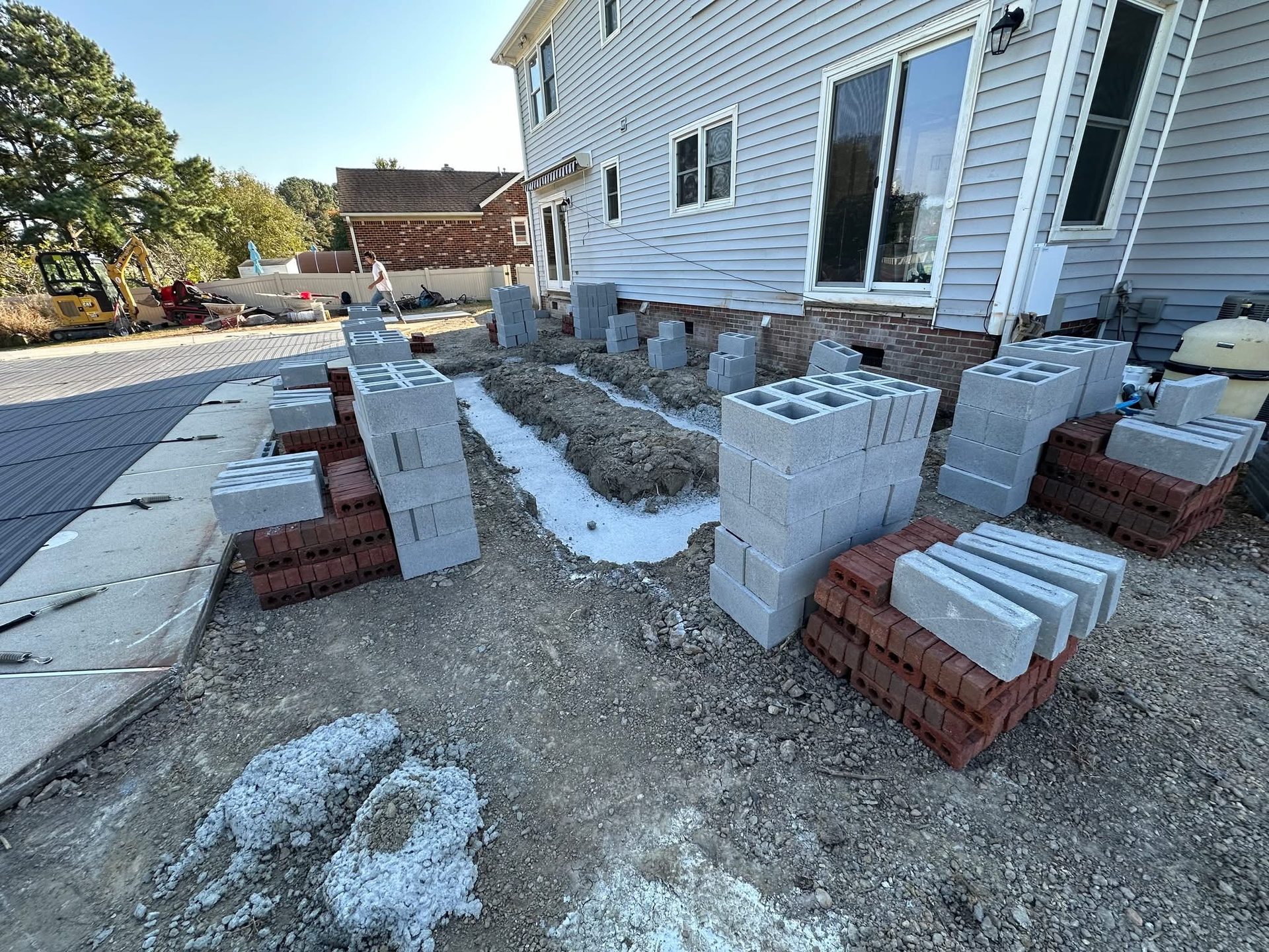 Block piers and brick pallets staged for foundation and footing work